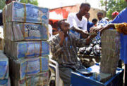 图中：索马里人在市场交易时使用成捆货币的情景